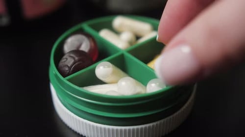 Hands Takes Pills From Pill Box Closeup Medical Pill Box with Doses of Tablets for Daily Take