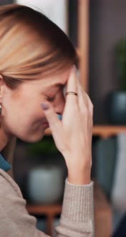 Thoughtful woman rests head in her hand