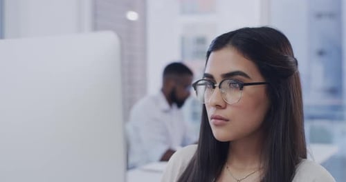 4k video footage of a young businesswoman working at her desktop pc in her office