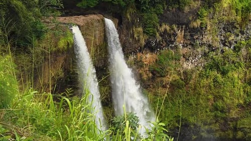 HD Câmera lenta Hawaii Kauai Foto estática de Wailua Falls com grama alta soprando para a direita em frente