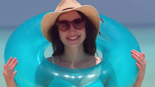 Smiling Woman with Inflatable Ring at the Beach