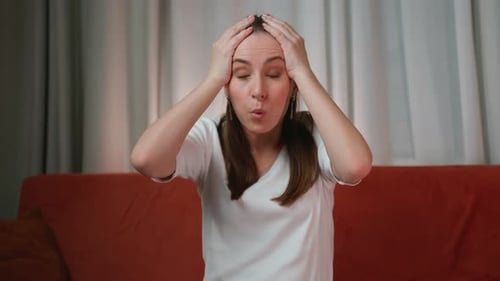 Woman Expressing Shock with Hands on Head