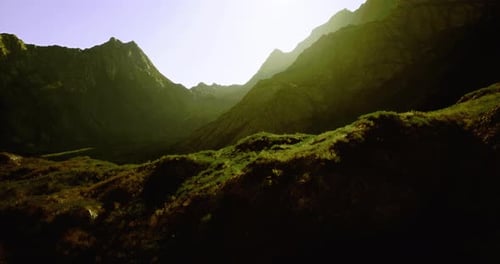 Mountain Landscape at Sunrise Showcasing Vibrant Greenery and Rocky Terrain