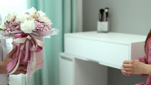 The man gives the girl a bouquet passing it into her hands. Close-up hand shots