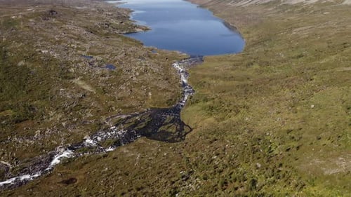 Aerial view of river and lake with mountain reveal