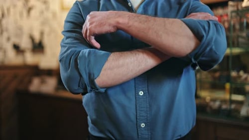 Food Service Professional Standing with Arms Crossed in Interior of Restaurant