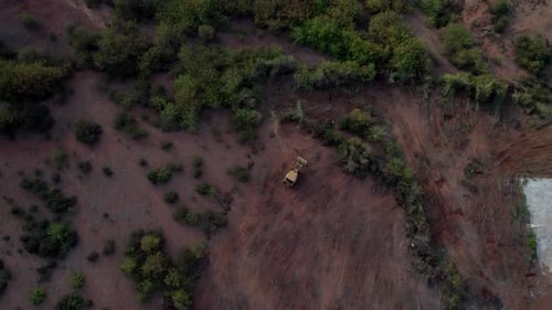 Aerial top-down view of a bulldozer clearing land vegetation