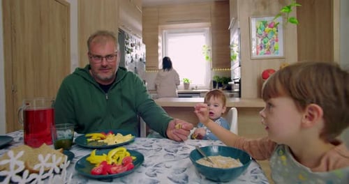 Family with Young Children Eating Breakfast Together at Home
