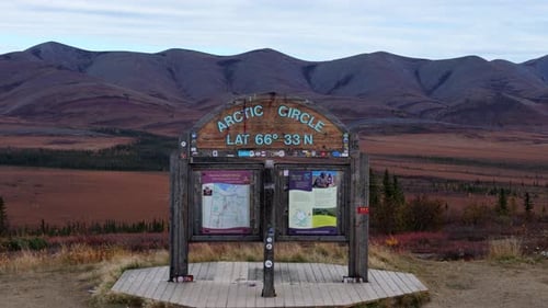 Sign Marking The Arctic Circle With Mountains In Background, Yukon,Canada - Drone Shot