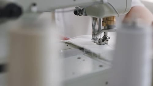 Gros plan, les mains d'une femme âgée utilisant une aiguille de machine à coudre se déplacent rapidement de haut en bas.