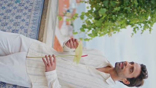 Smiling Man Holding Flower Cloudy Viewpoint Vertically Zoom on Guy Looking Sea