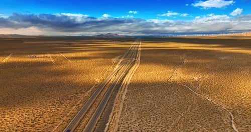 Rare cars moving by the highways in the desert. Beautiful landscape in the azure sky at backdrop.