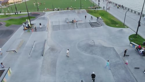 Teenagers Have Fun in Concrete Skating Pool on Riverbank