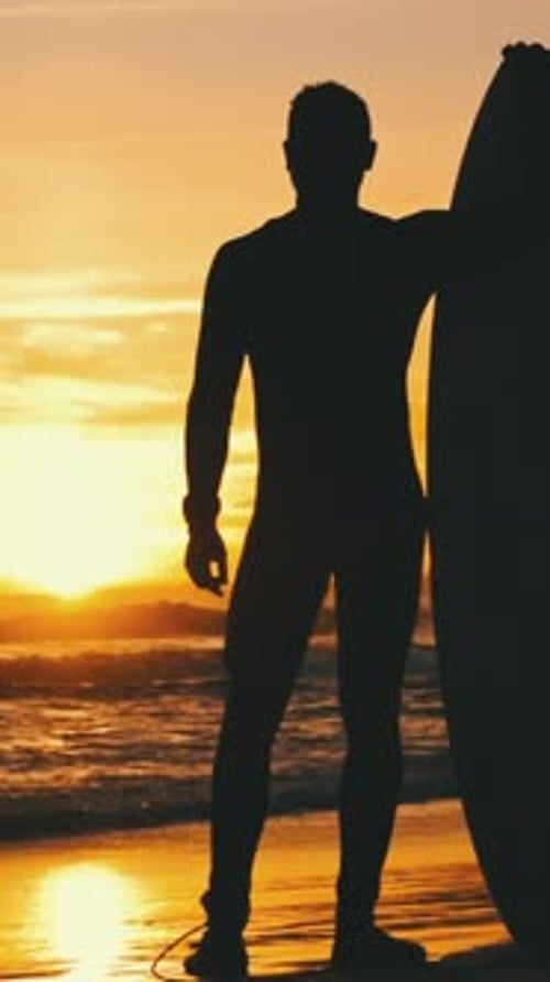 Silhouette of a Man Standing on the Seashore at Sunset