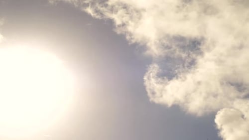 Clouds passing in the blue sky with the sun popping in and out