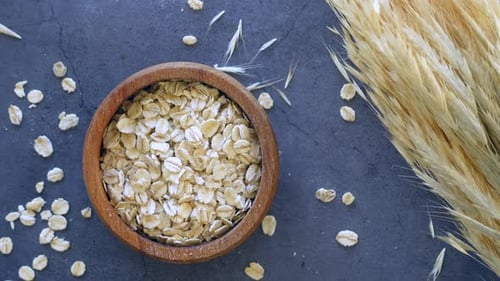 Roasted Oats Flakes in a Bowl on Black Background