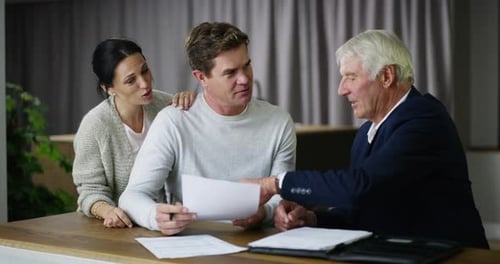 Couple reading and signing finance documents, paying for a loan and making investment