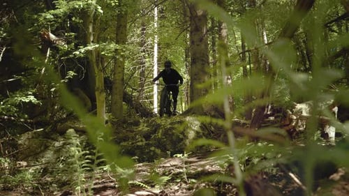 Shot of a young athletic man on MTB e-bike riding down the rocks. Extreme sport in the nature.