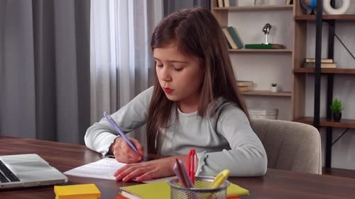 Young Child Girl Studying at Home Small Girl Sits at Desk and Attends School Class Online on Laptop