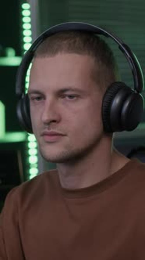 Vertical Portrait of Young Male Programmer at Computer Desk in Office at Night