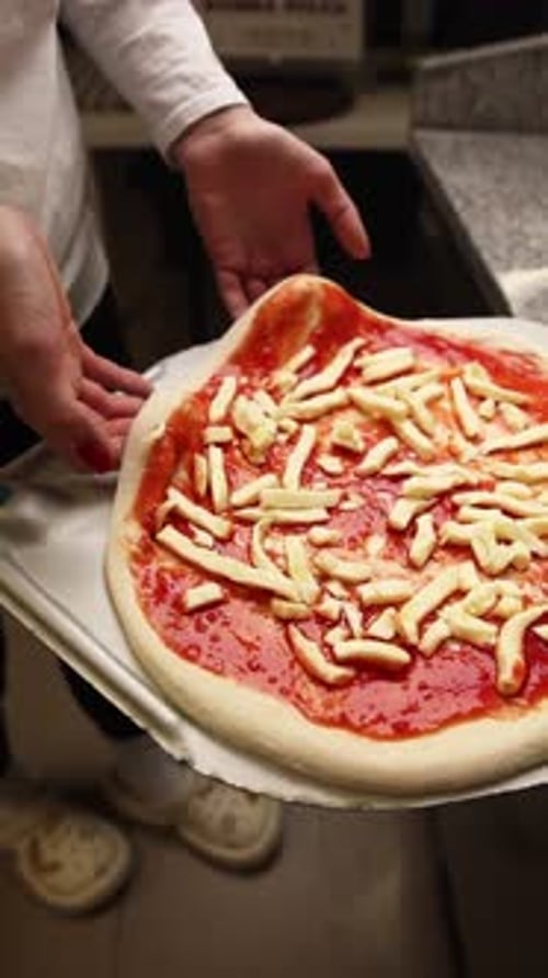 The chef makes delicious pizza in a professional kitchen.