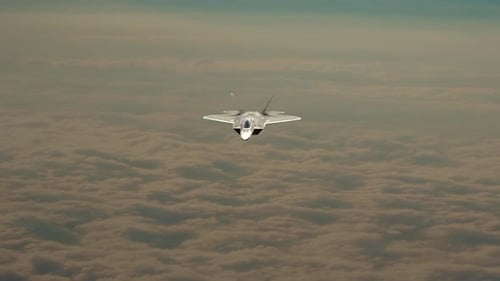 Modern Fighter Jet Flying Above Clouds