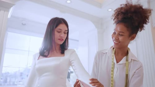 Beautiful bride discussing details with the wedding planner in studio.