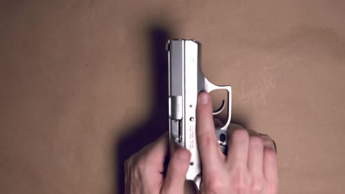 Hands loading 9mm pistol with magazine and getting stuck.Dangerous maneuver.Close up shot.