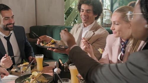 Group of people sitting in a restaurant at a business lunch.