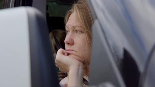 Pensive Woman Gazing from Car Window