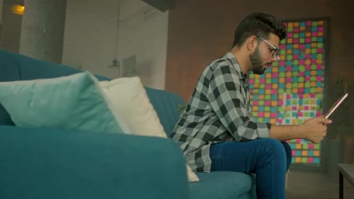 Young Man Relaxing at Home with Tablet