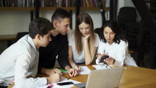 Groupe d'étudiants : des lycéens se réunissent dans la bibliothèque du collège pour discuter de sujets sur lesquels travailler ensemble