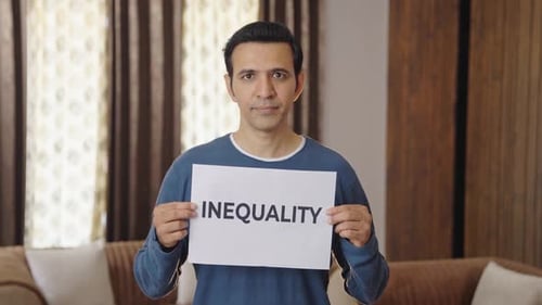 Man Holding Inequality Sign Indoors