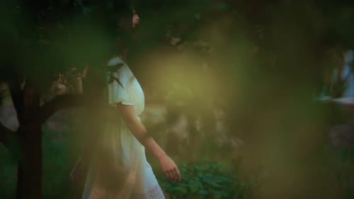 Young Woman Walking Calmly in Green Garden