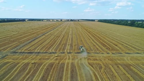 Hay Baler Traktor fährt über das Feld, sammelt Strohhalme und macht die Ballen Luftbild in
