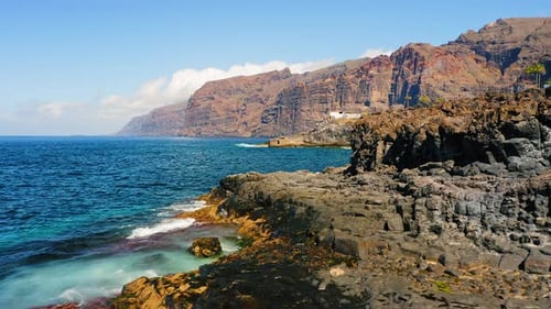 Man Tourist Enjoys Ocean View From Rocky Beach on Volcanic Tenerife Island