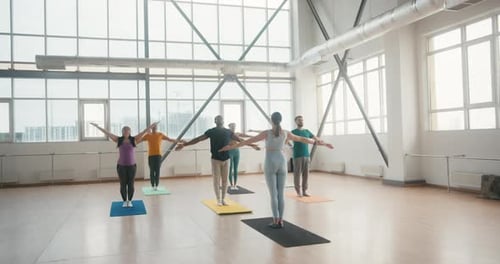 Coach with Group Prepares for Yoga Class in Fitness Gym