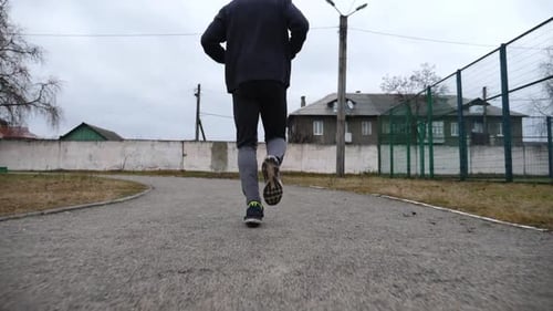 Strong Sportsman Running at Track on School Stadium in Cloudy Day Young Male Athlete Working Out at
