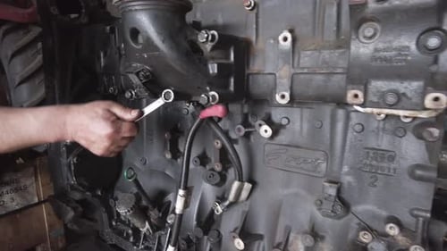 Man Repairing Engine with Wrench Close Up
