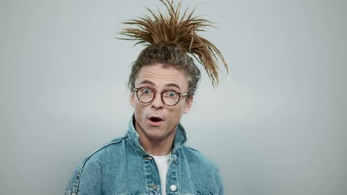 Man with dreadlocks looking surprised at camera