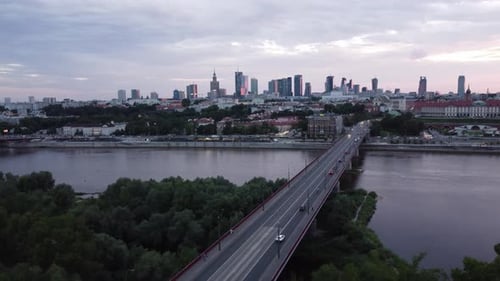 Cinematic drone footage of Warsaw skyline with vistula river and bridge filled with traffic left par