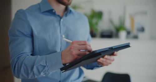 Man Using Tablet with Stylus Indoors