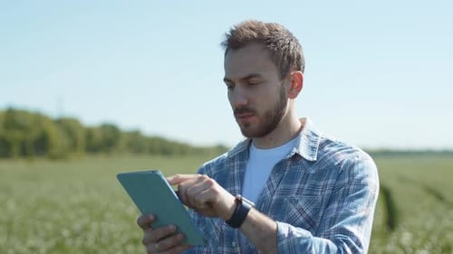 Adult Farmer Uses Tablet in Rural Field