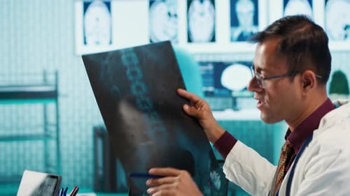 Doctor Reviews X-rays with Patient in Office