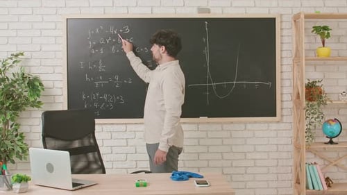 Man Explaining Math Equations on Chalkboard in Classroom