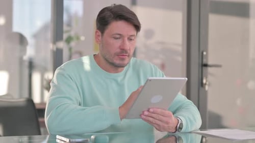 Man Using Tablet at Desk Indoors