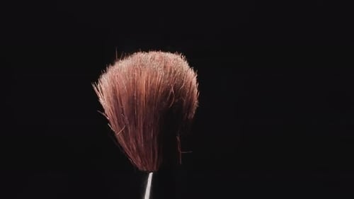 Alter Make-up-Pinsel mit langen harten Borsten auf schwarzem Hintergrund