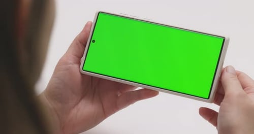 Closeup of Woman Hands Holding Smartphone with Green Screen