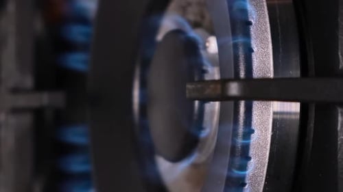 A Closeup of the Ignition of a Gas Stove Gas Burns with a Blue Flame in a Dark Room Vertical Video