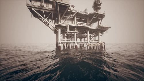 Historic Oil Platform Standing Above the Tranquil Ocean Waves at Sunset